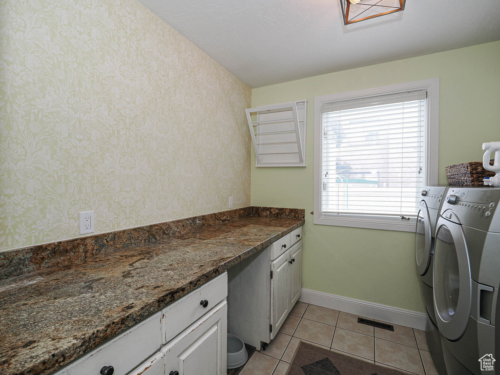 Laundry room with visible vents, cabinet space, light tile patterned floors, baseboards, and separate washer and dryer