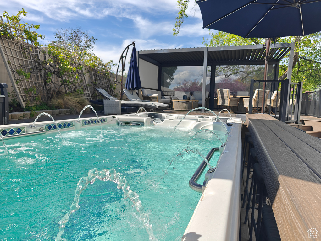 View of swimming pool featuring an outdoor living space, a fenced backyard, and a jacuzzi