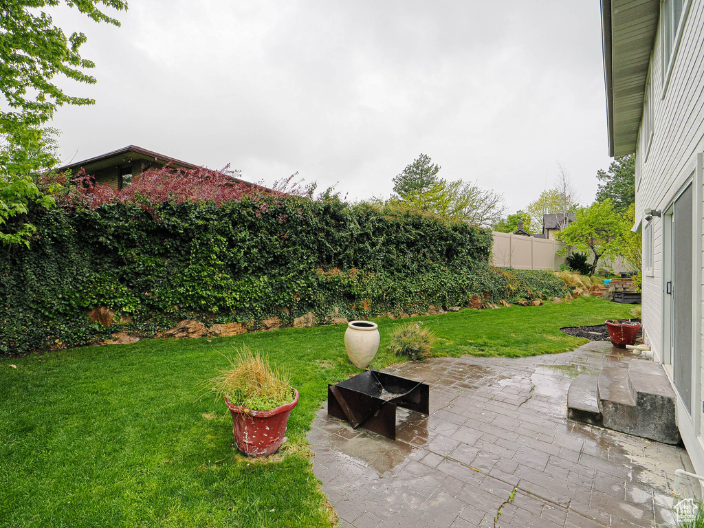 View of yard with fence and a patio area