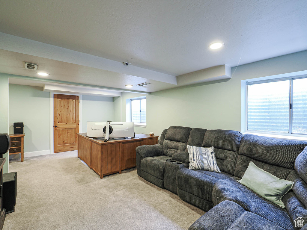 Living area with recessed lighting, baseboards, visible vents, and light carpet