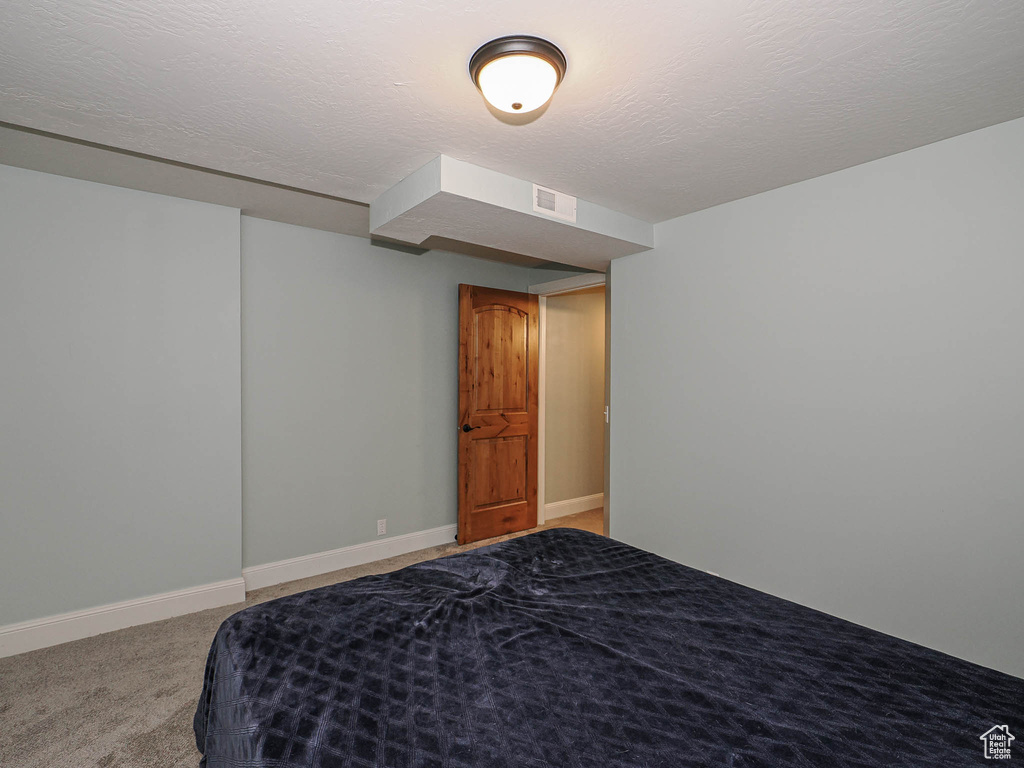 Bedroom featuring baseboards, light carpet, and visible vents