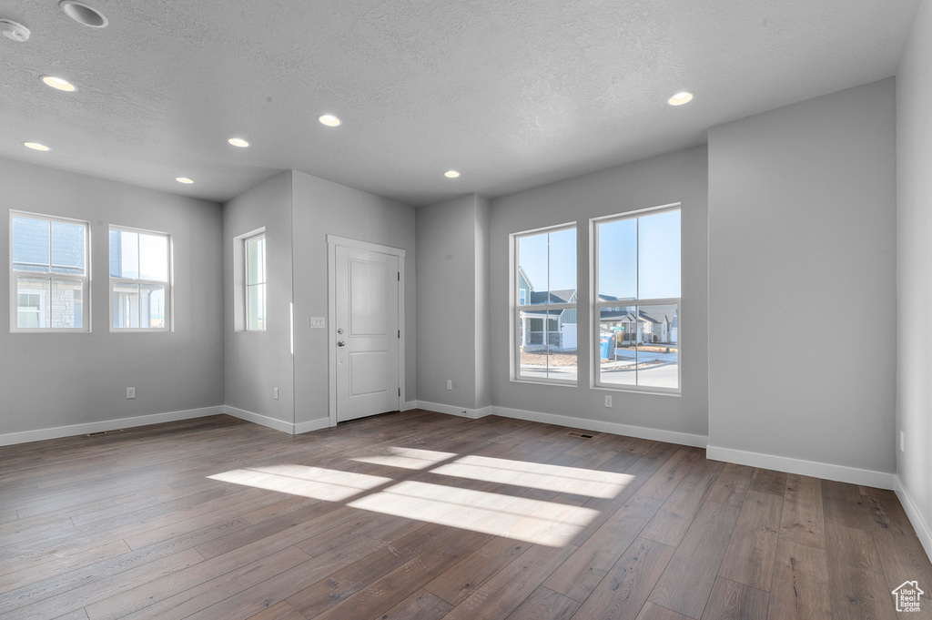 Interior space featuring baseboards, recessed lighting, a textured ceiling, and hardwood / wood-style flooring