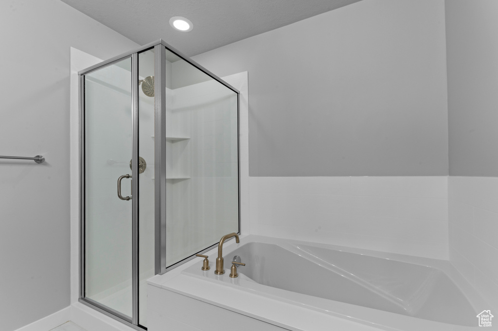 Full bathroom featuring a stall shower, recessed lighting, and a bath