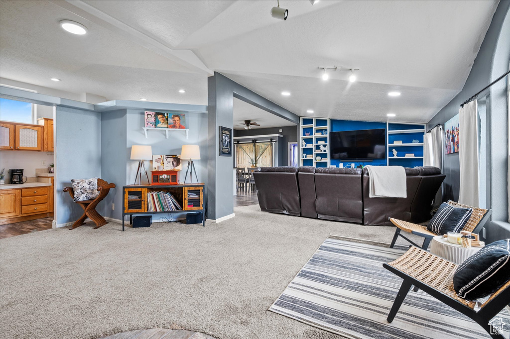 Living room featuring carpet floors, recessed lighting, baseboards, and lofted ceiling