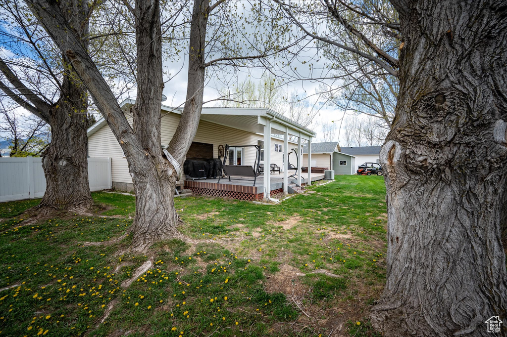 View of yard with fence and a deck