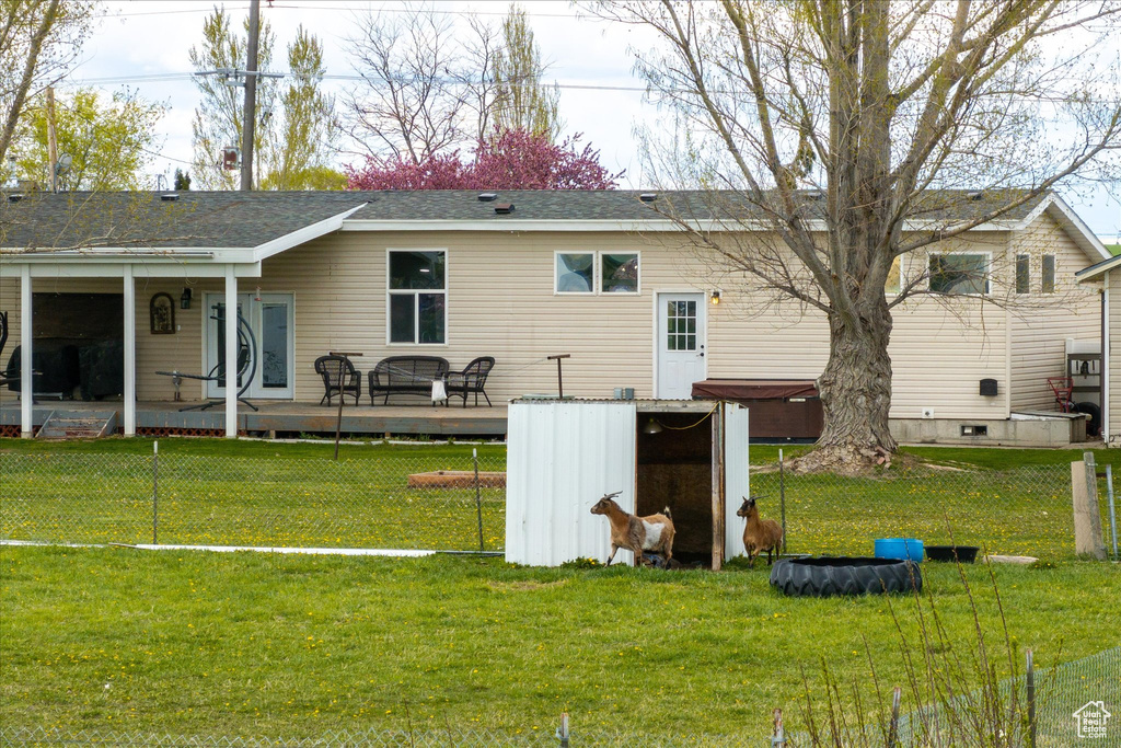 Rear view of property with a lawn and a shingled roof