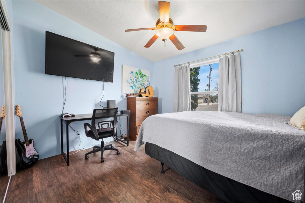Bedroom with a ceiling fan, wood finished floors, and vaulted ceiling