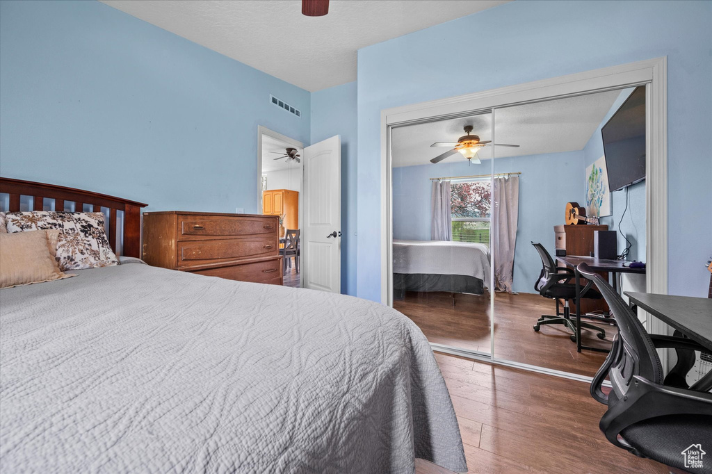 Bedroom featuring ceiling fan, visible vents, wood finished floors, and a closet