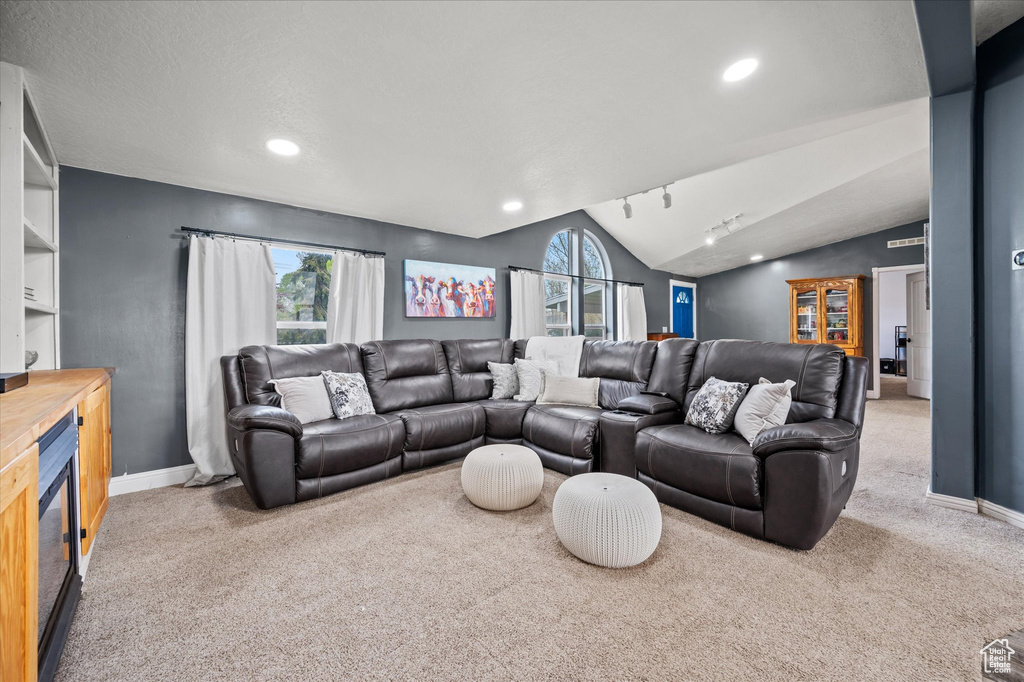 Living room featuring carpet floors, baseboards, vaulted ceiling, and recessed lighting