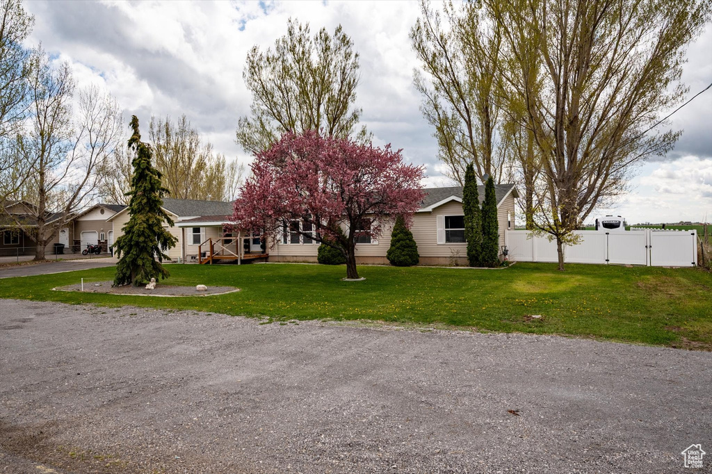 View of front of home with fence, a gate, and a front lawn