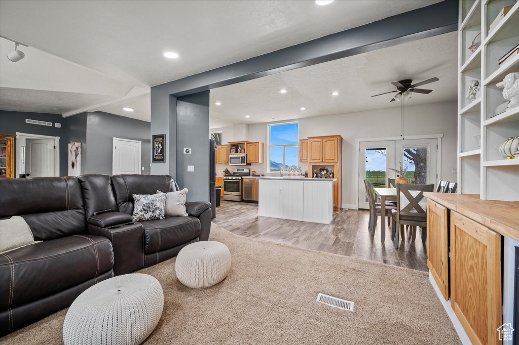 Living room with visible vents, a ceiling fan, recessed lighting, and light wood-type flooring