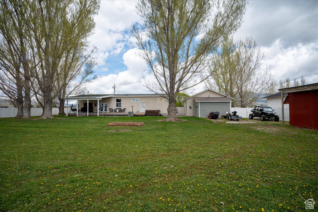 Exterior space featuring fence, an outbuilding, a garage, and a front yard