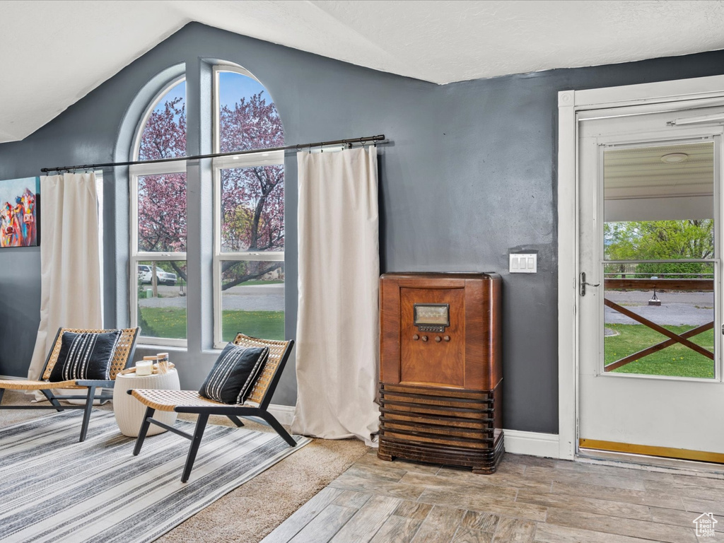 Interior space featuring baseboards, vaulted ceiling, and wood finished floors