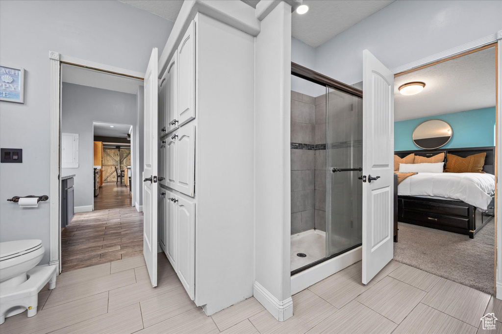 Ensuite bathroom with ensuite bathroom, a stall shower, and toilet