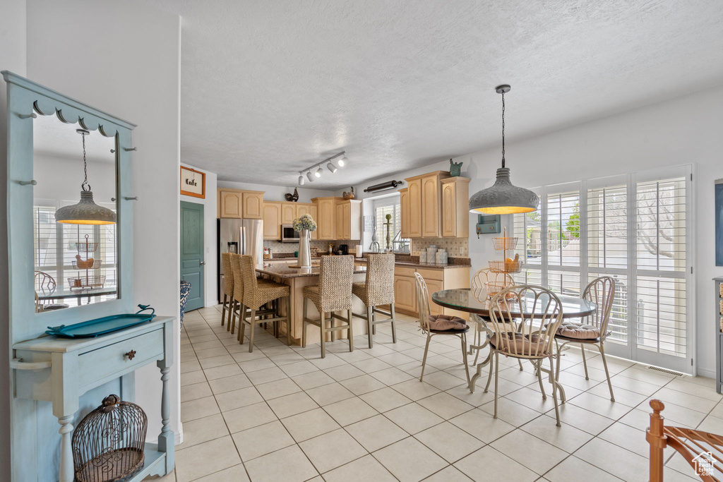 Dining area with a textured ceiling and light tile patterned flooring