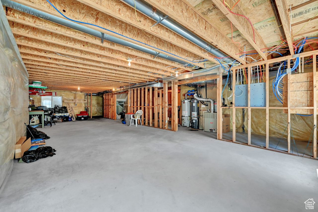 Unfinished basement featuring heating unit and water heater