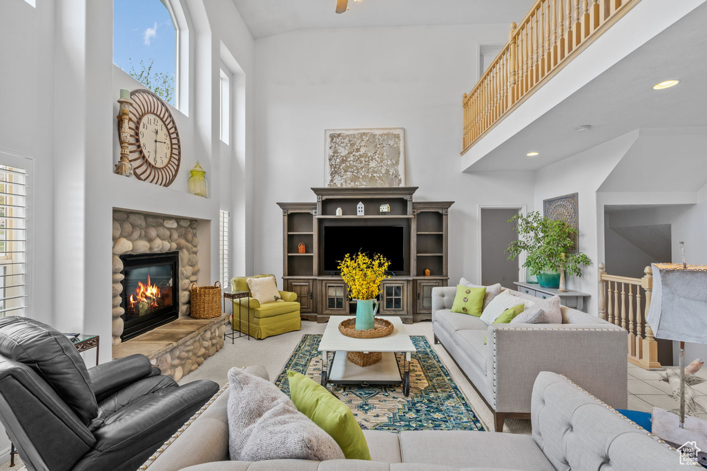 Living area featuring recessed lighting, a towering ceiling, and a fireplace