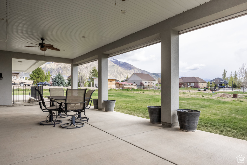 View of patio / terrace featuring a residential view, a ceiling fan, a mountain view, and outdoor dining space