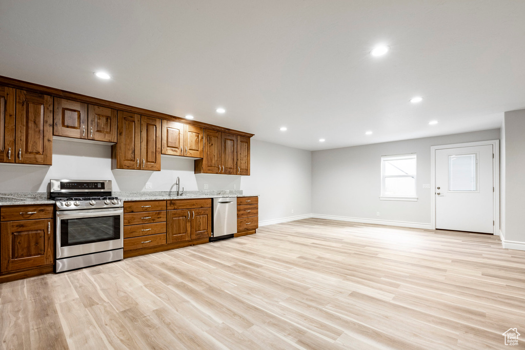Kitchen with recessed lighting, light wood-style flooring, baseboards, and stainless steel appliances