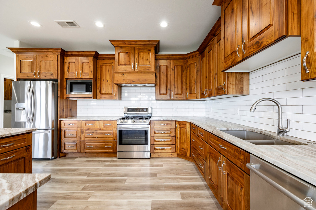 Kitchen with visible vents, a sink, brown cabinetry, and stainless steel appliances