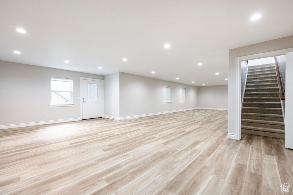 Basement featuring baseboards, recessed lighting, light wood finished floors, and stairway
