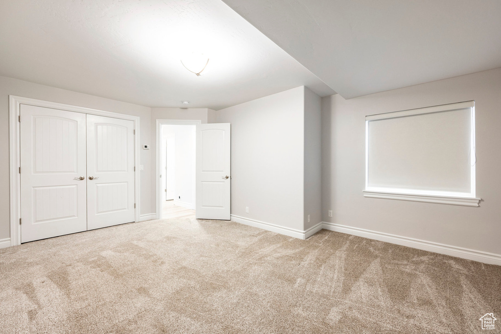 Unfurnished bedroom featuring baseboards, carpet, and a closet