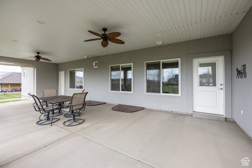 View of patio with outdoor dining area and ceiling fan