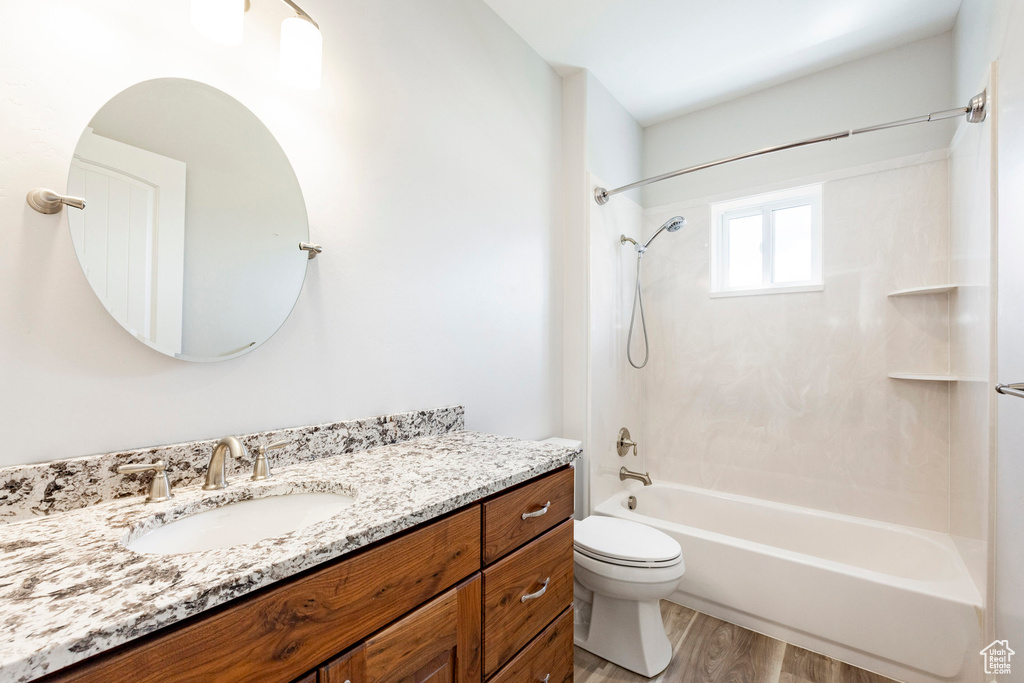 Full bathroom with vanity, wood finished floors, bathtub / shower combination, and toilet