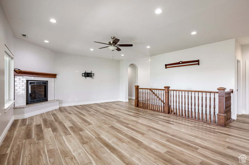 Unfurnished living room with recessed lighting, arched walkways, a ceiling fan, and light wood-style flooring