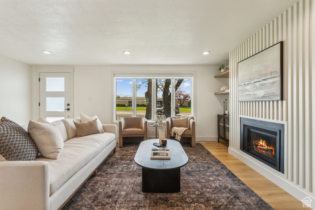 Living area featuring a glass covered fireplace, recessed lighting, and light wood-type flooring
