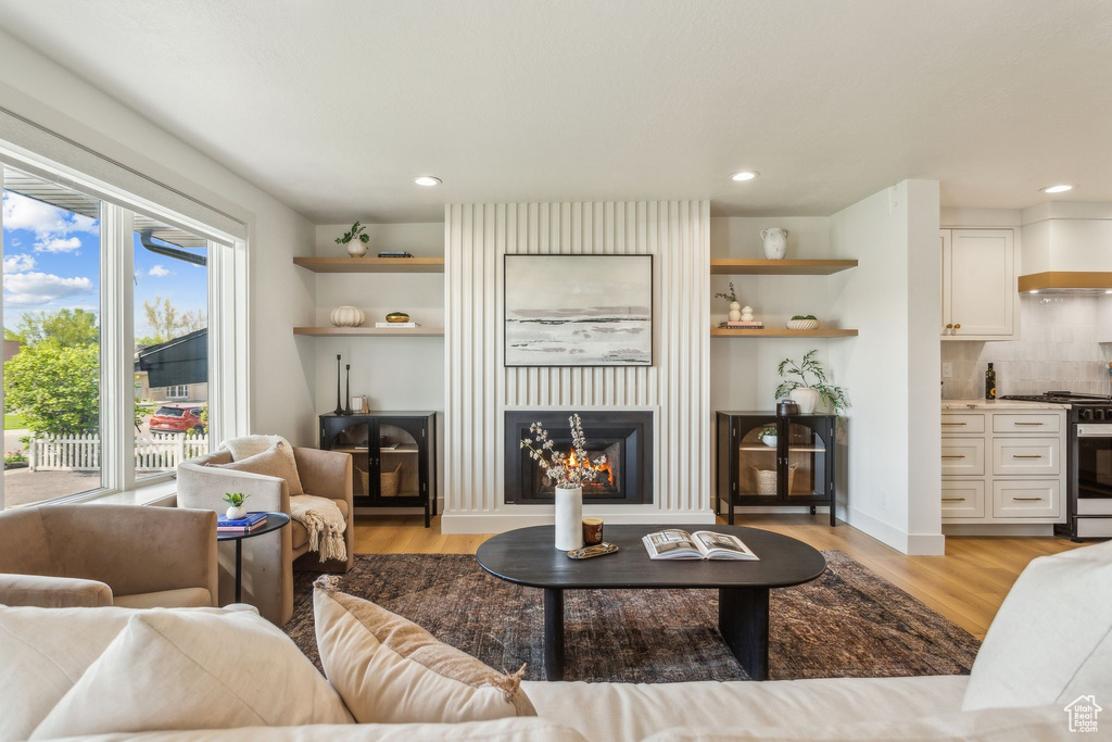 Living room with a fireplace, recessed lighting, and light wood-style floors