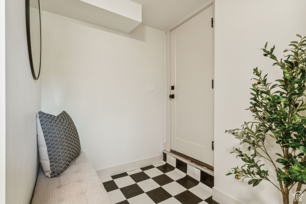 Doorway featuring tile patterned floors and baseboards