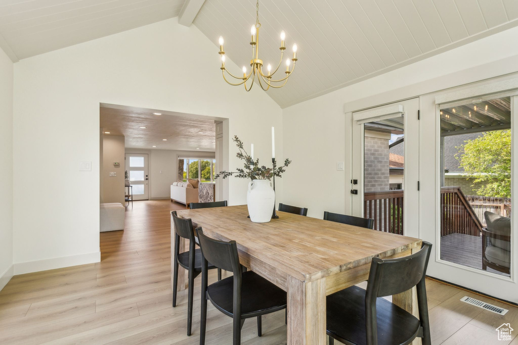 Dining space with visible vents, beam ceiling, light wood-style floors, high vaulted ceiling, and a chandelier
