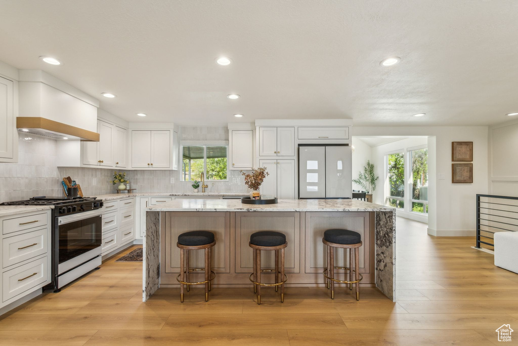 Kitchen with plenty of natural light, refrigerator, range with gas stovetop, and a center island