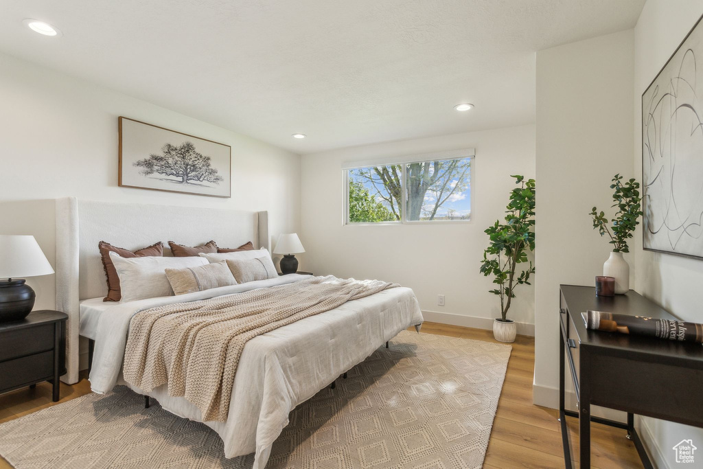 Bedroom with light wood-style floors, baseboards, and recessed lighting