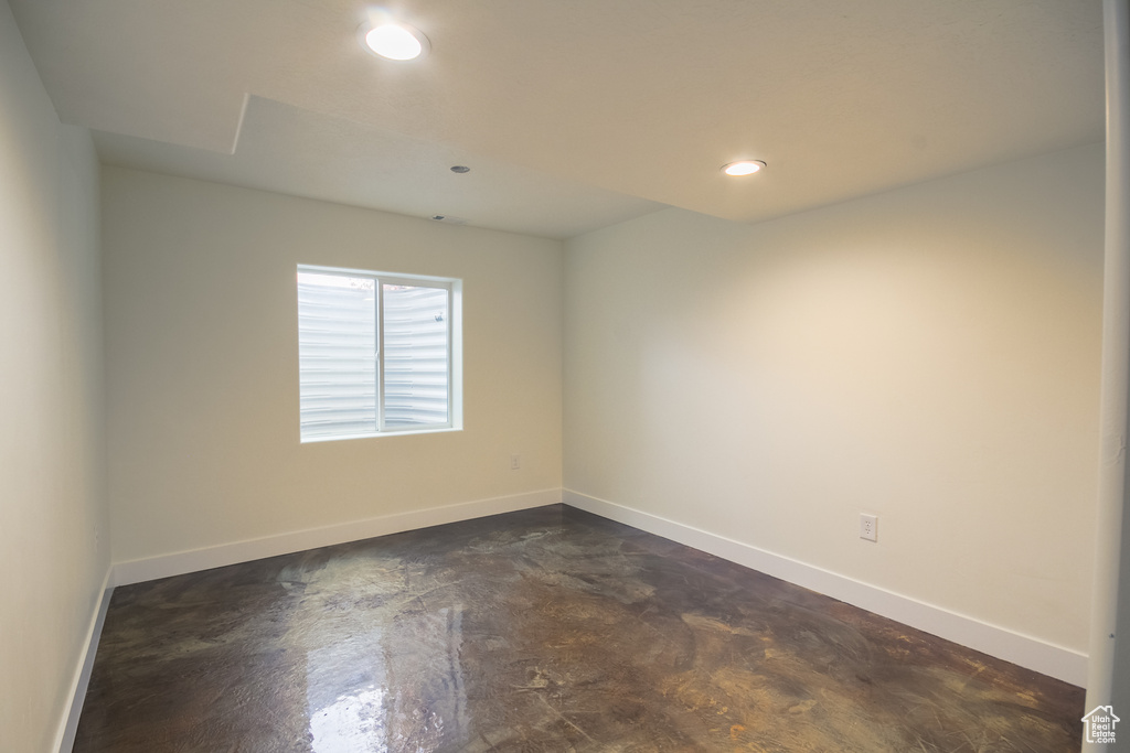 Empty room with baseboards, concrete flooring, and recessed lighting