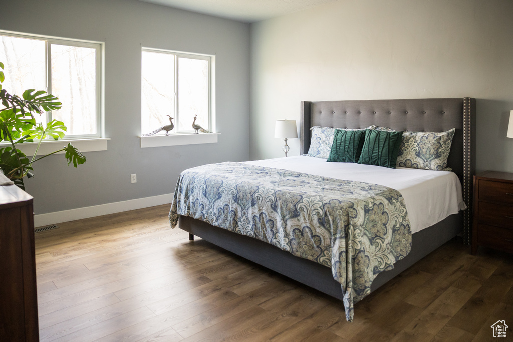 Bedroom featuring baseboards, wood finished floors, and visible vents