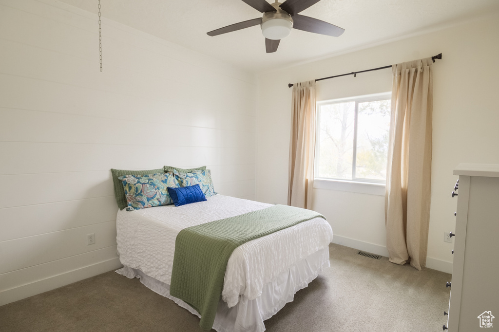 Carpeted bedroom with baseboards, a ceiling fan, and visible vents