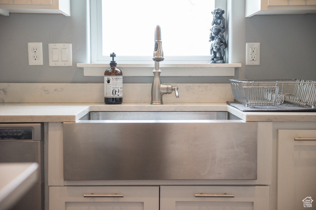 Details with light countertops, a sink, and white cabinetry