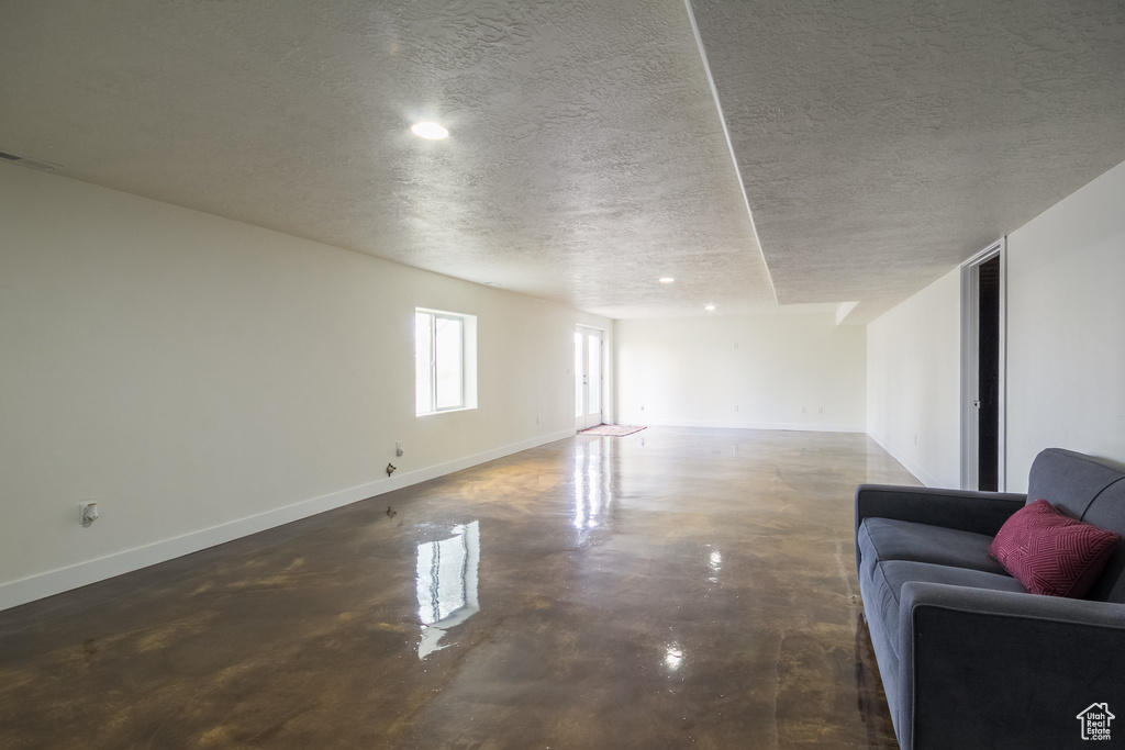 Below grade area with baseboards, recessed lighting, and a textured ceiling