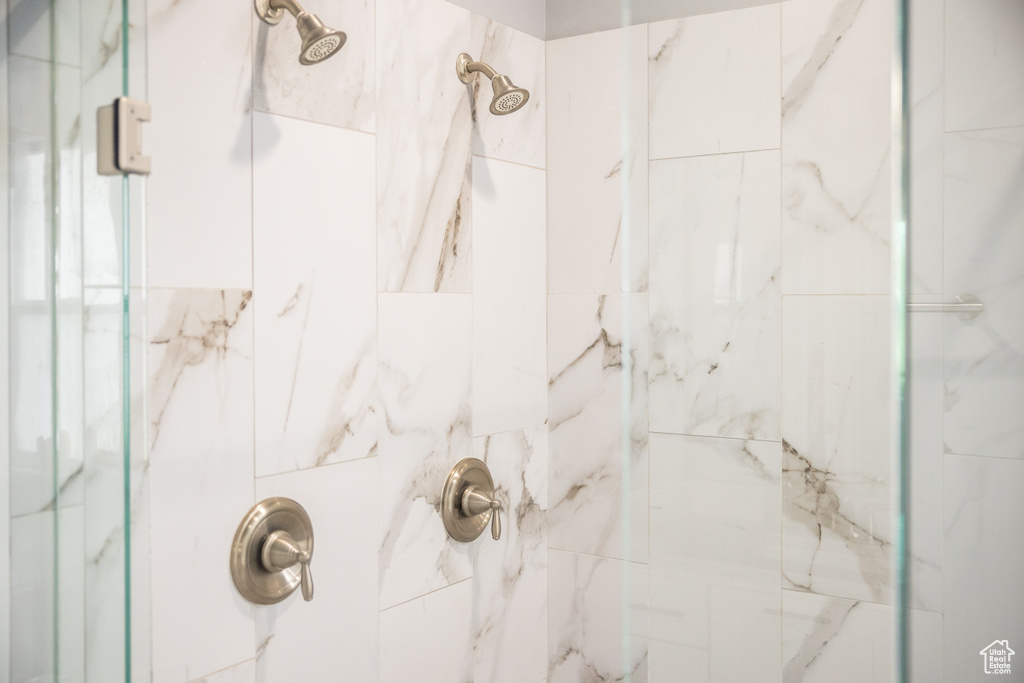 Full bath featuring a marble finish shower