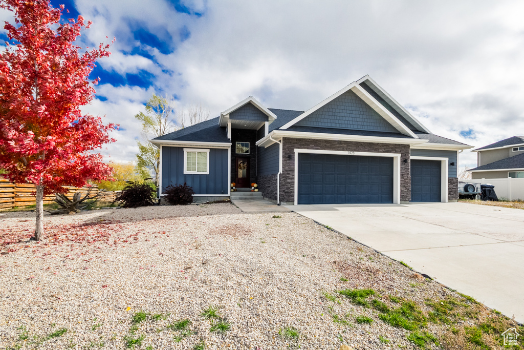 View of front of house featuring an attached garage, board and batten siding, fence, and concrete driveway