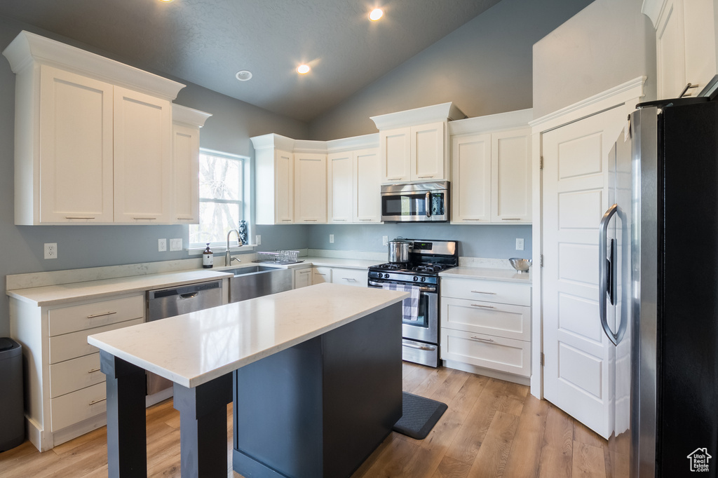 Kitchen featuring light countertops, white cabinets, and appliances with stainless steel finishes