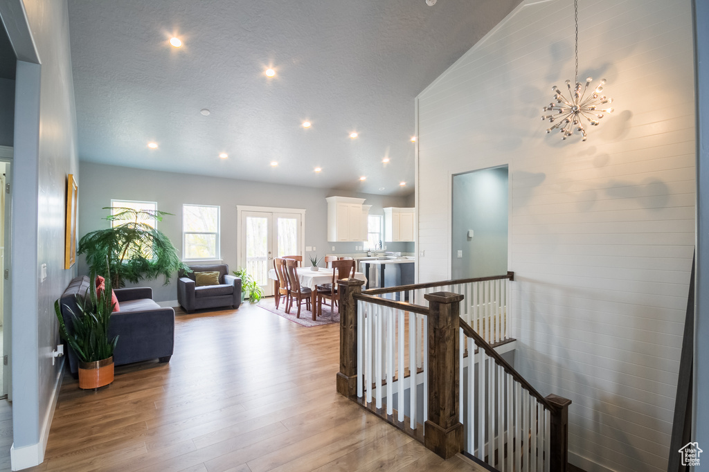 Hallway with baseboards, recessed lighting, wood finished floors, and an upstairs landing