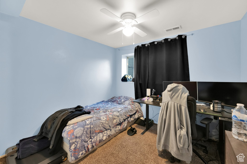 Bedroom with carpet flooring, a ceiling fan, and visible vents