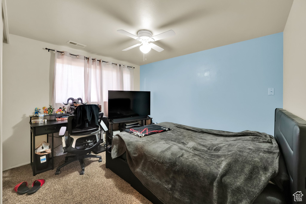 Carpeted bedroom with a ceiling fan and visible vents