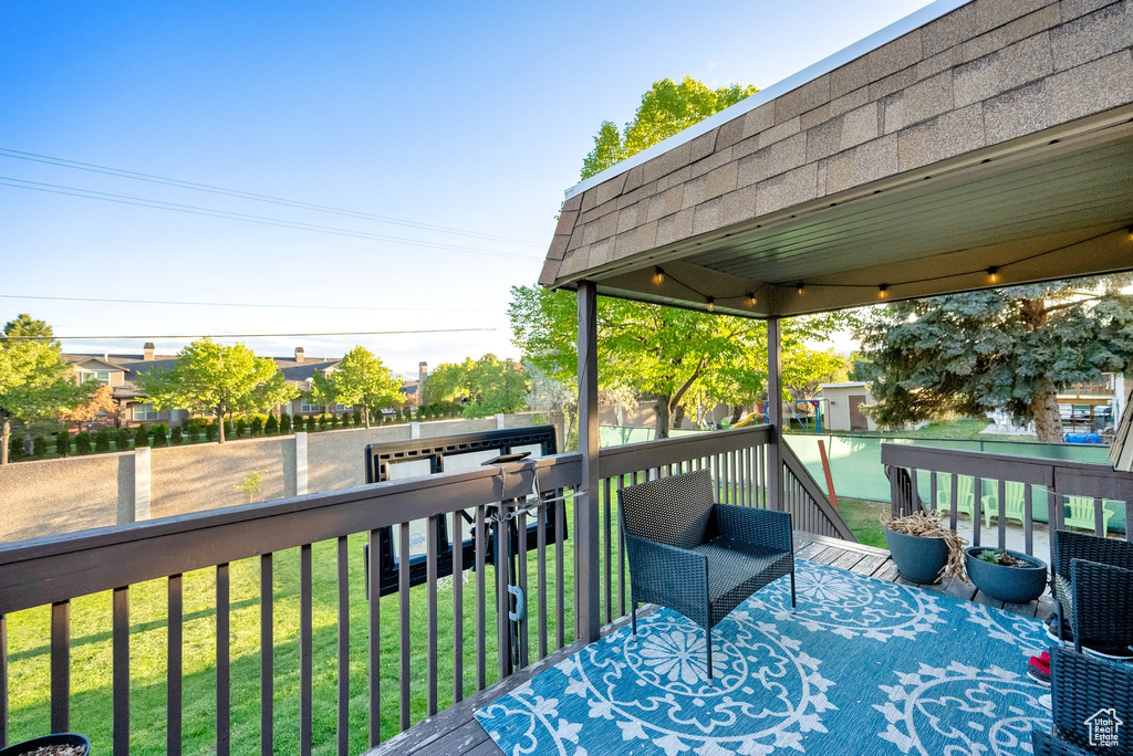 Wooden terrace with a lawn and a fenced backyard
