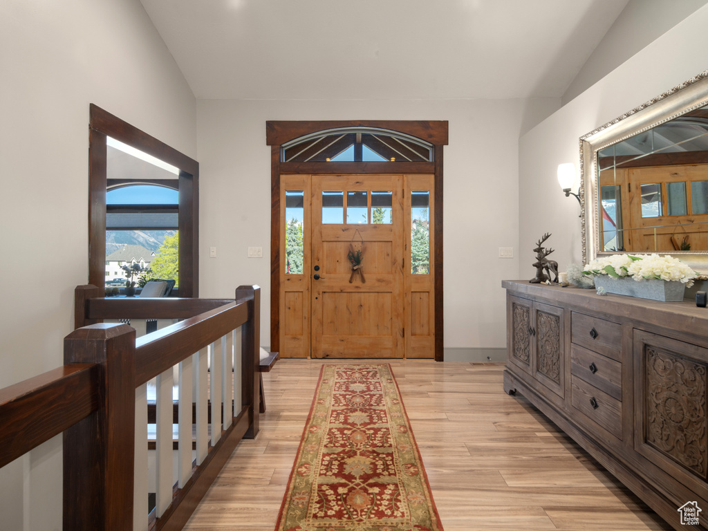 Foyer entrance featuring light wood-style flooring and lofted ceiling