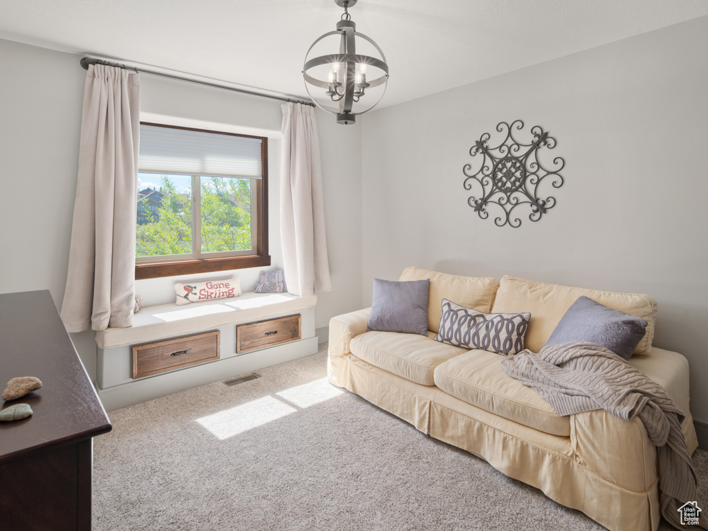 Carpeted living room featuring a notable chandelier