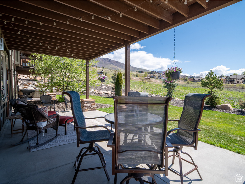 View of patio with a mountain view and outdoor dining area